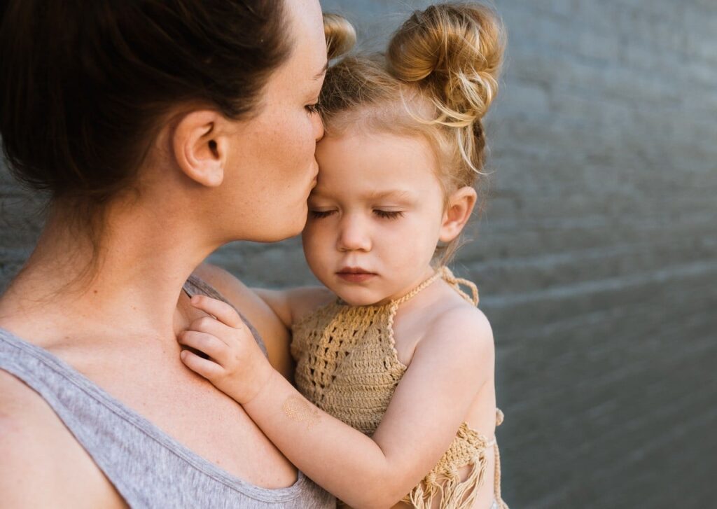 mom kissing baby girl